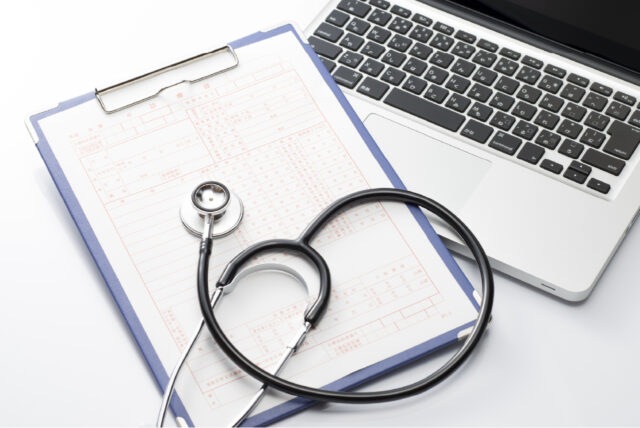 ノートパソコンとバインダーと聴診器