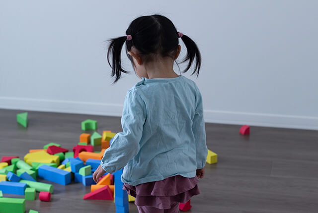 子供が暗い部屋で一人で遊んでいる様子